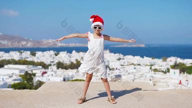 有趣的女孩<strong>红色</strong>的圣诞老人他在户外背景米克诺斯孩子街典<strong>型</strong>的希腊传统的村白色墙色彩斑斓的<strong>门</strong>圣诞节假期希腊